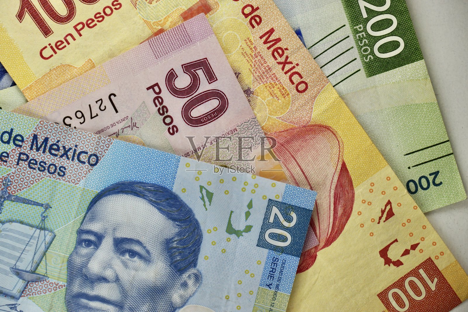 许多墨西哥比索纸币随机地散布在一个平面上照片摄影图片