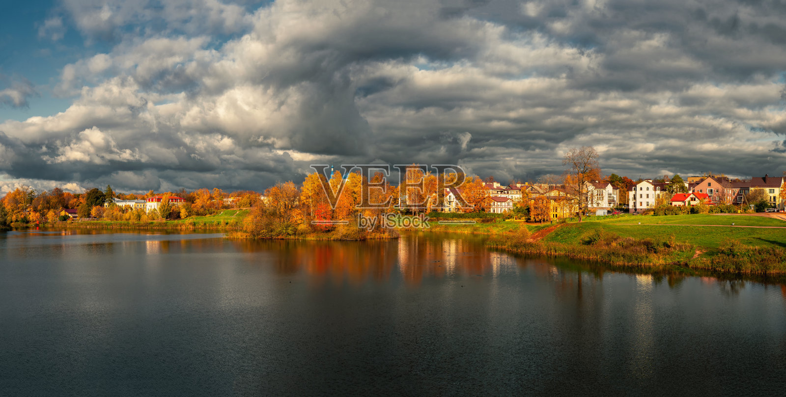 广阔的乡村景色，村舍和湖边的黄树。照片摄影图片