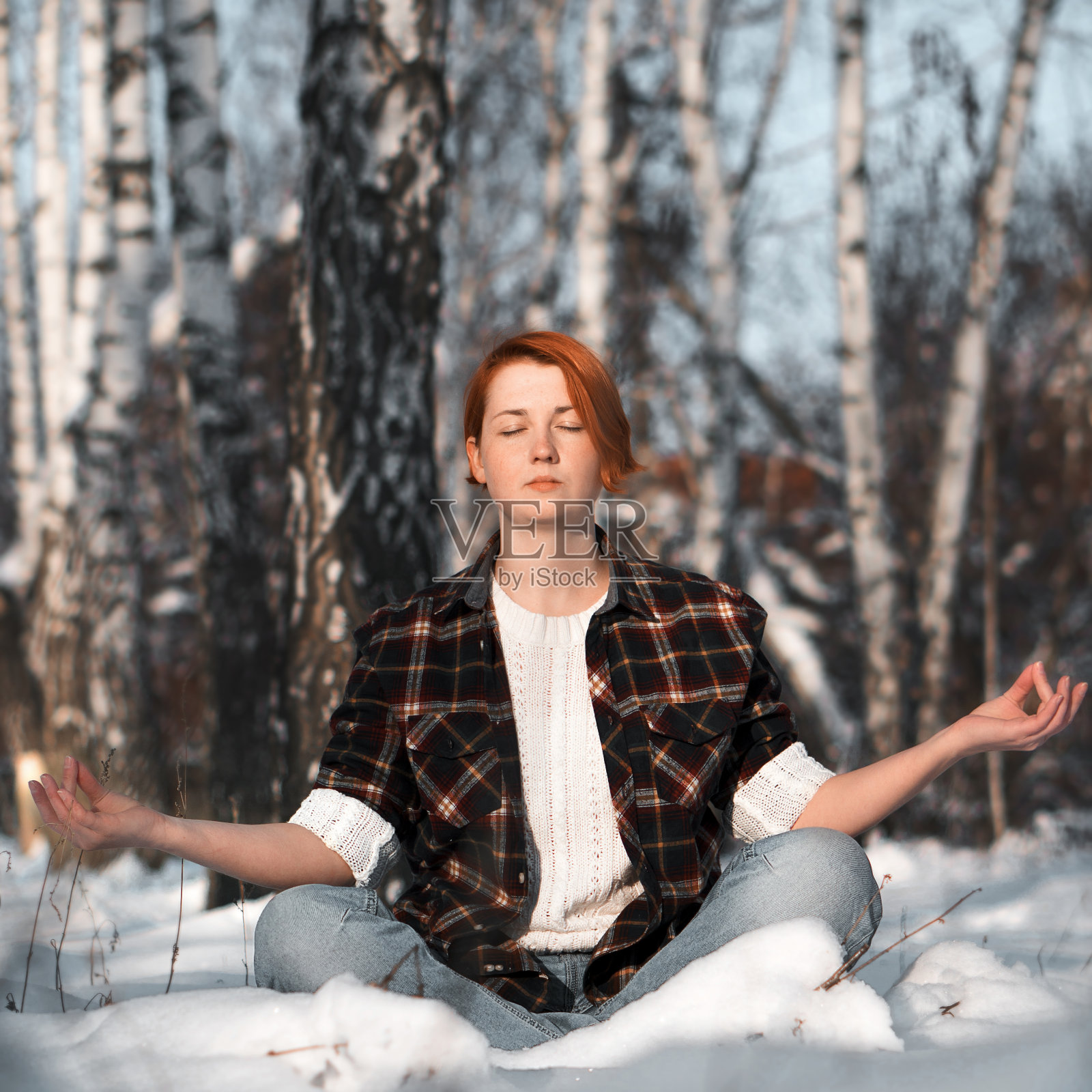 可爱的姜姑娘在冬天的森林里沉思。照片摄影图片