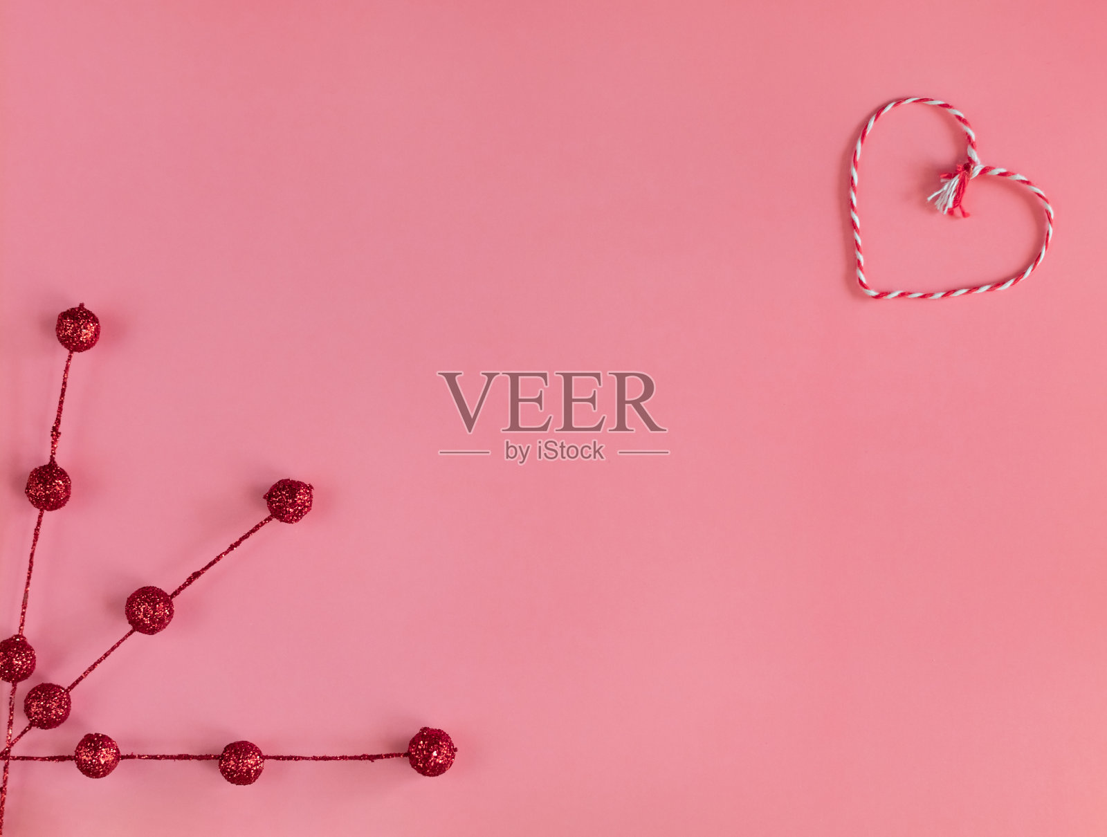 情人节作文。心形由线和装饰红色的树枝在粉红色的背景。贺卡。平铺，俯视图，拷贝空间。照片摄影图片