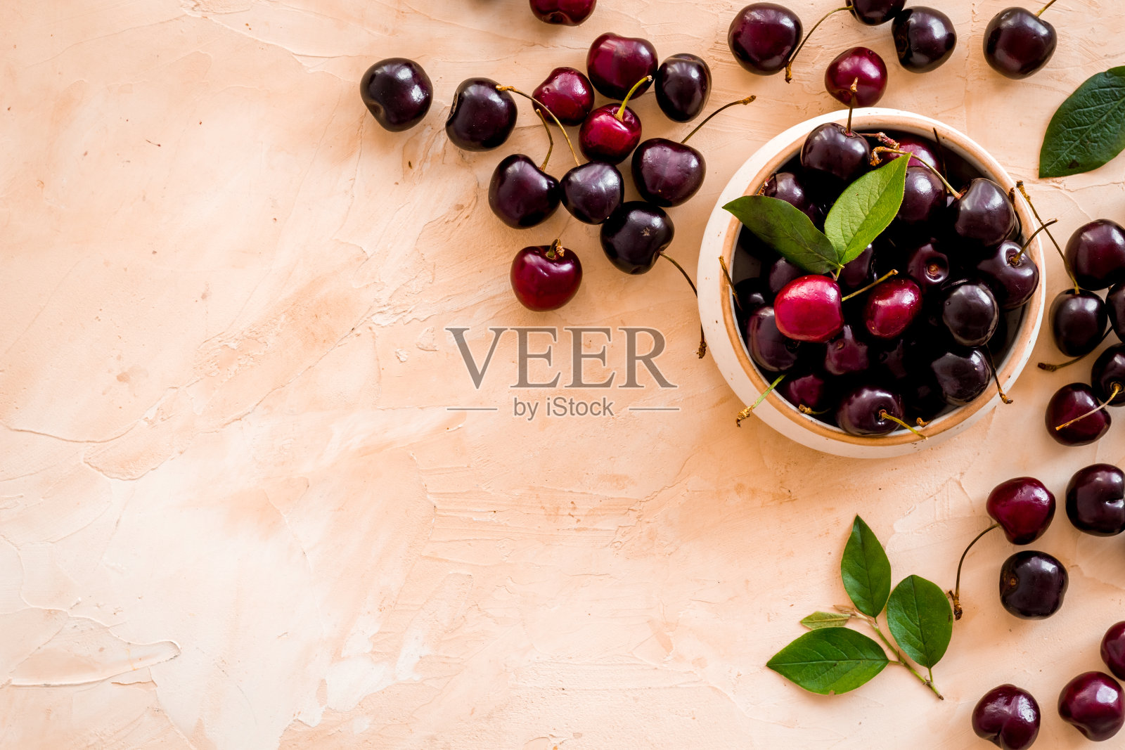 木碗里的带叶子的红樱桃。布局,浆果背景照片摄影图片