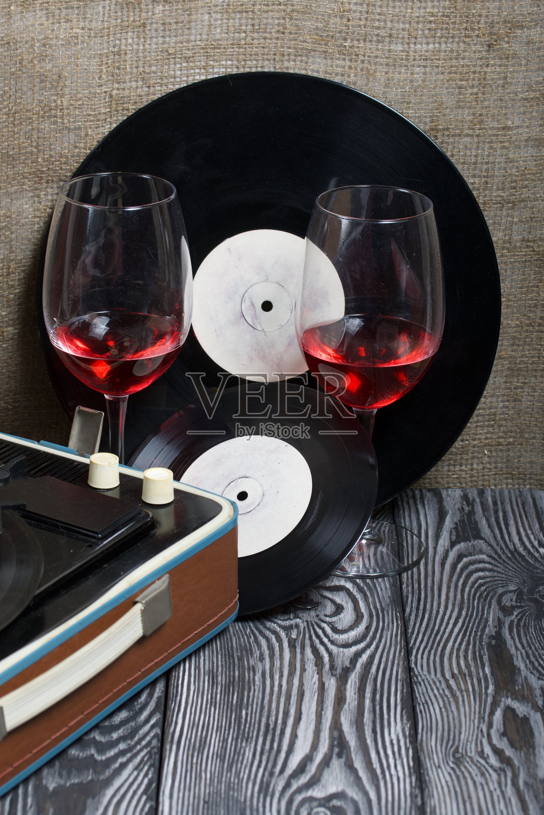 旧的转盘。旁边有两杯酒。复古方设备。照片摄影图片