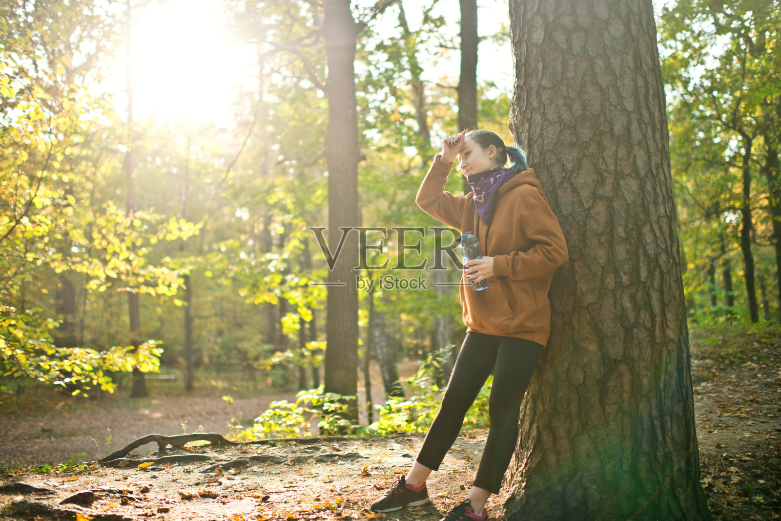 十几岁的女孩在运动或跑步后戴着头巾在公园休息照片摄影图片