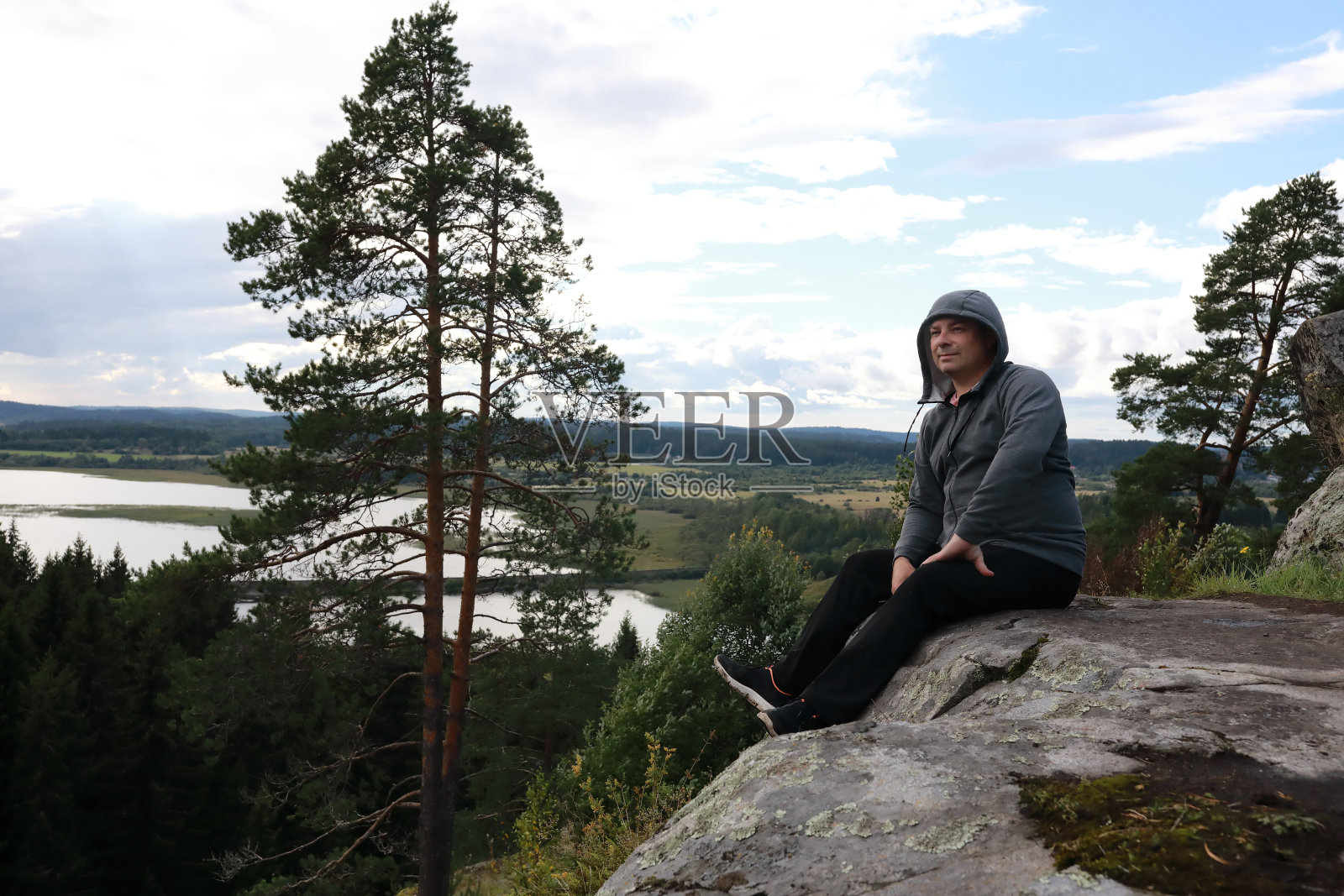 一名男子坐在卡累利阿帕索山上的石头上照片摄影图片