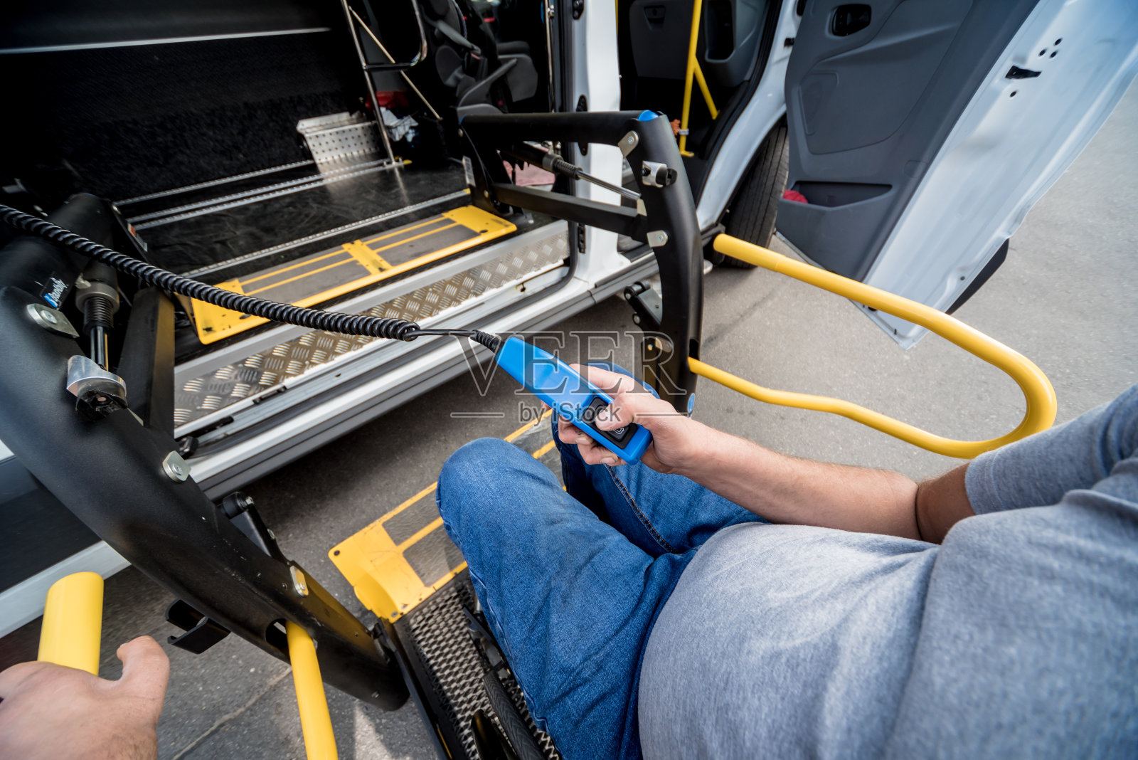 残疾人在残疾人专用交通工具的电梯上坐轮椅的人照片摄影图片