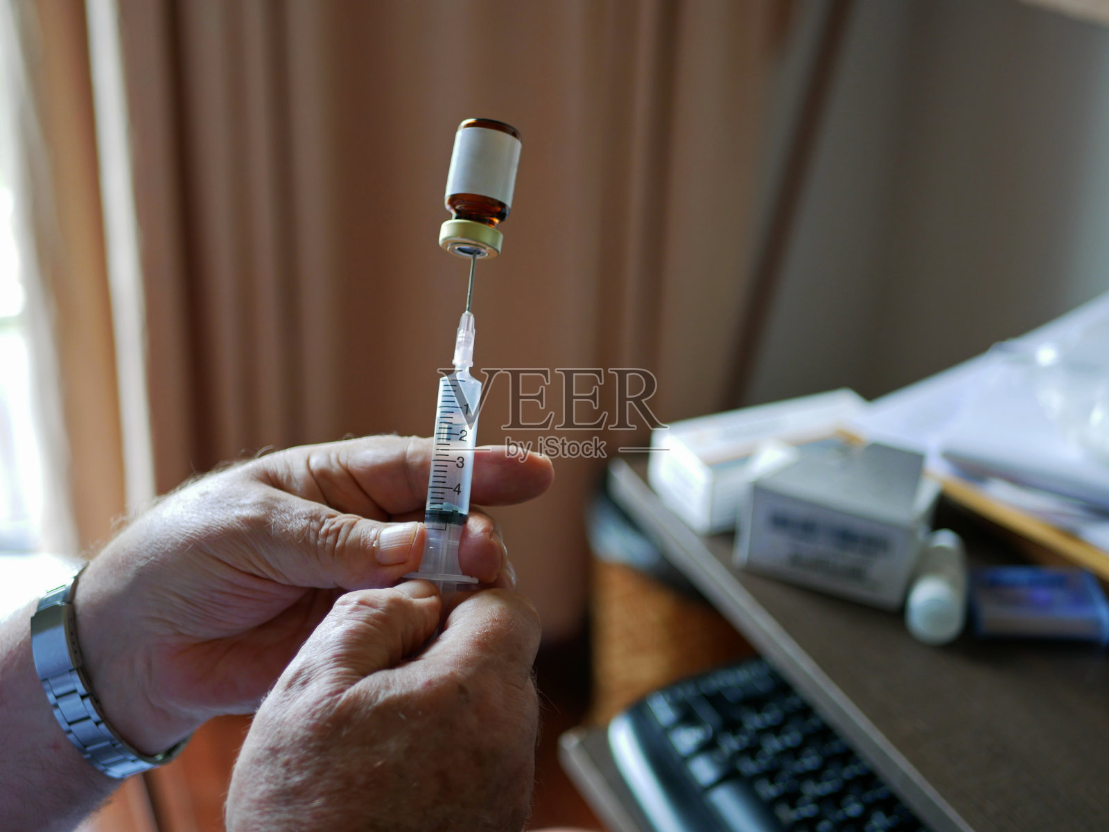 一位老人的手小心翼翼地把药拉进注射器里，自己在家给老人注射照片摄影图片