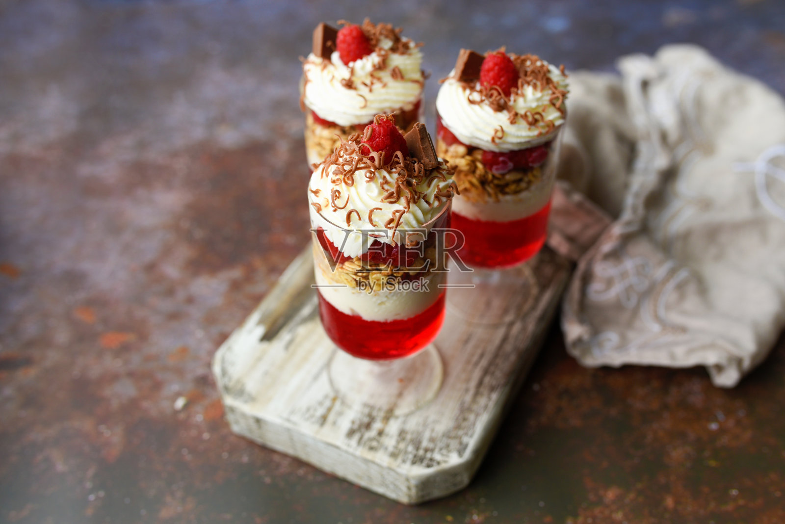 杯装甜点，覆盆子果冻，格兰诺拉麦片，酸奶和奶油照片摄影图片