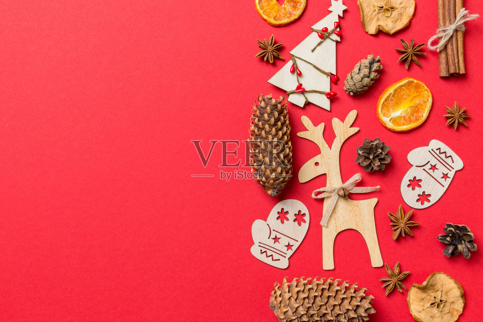 红色背景上装饰着节日玩具和圣诞符号驯鹿和新年树的俯视图。具有复制空间的节日概念照片摄影图片
