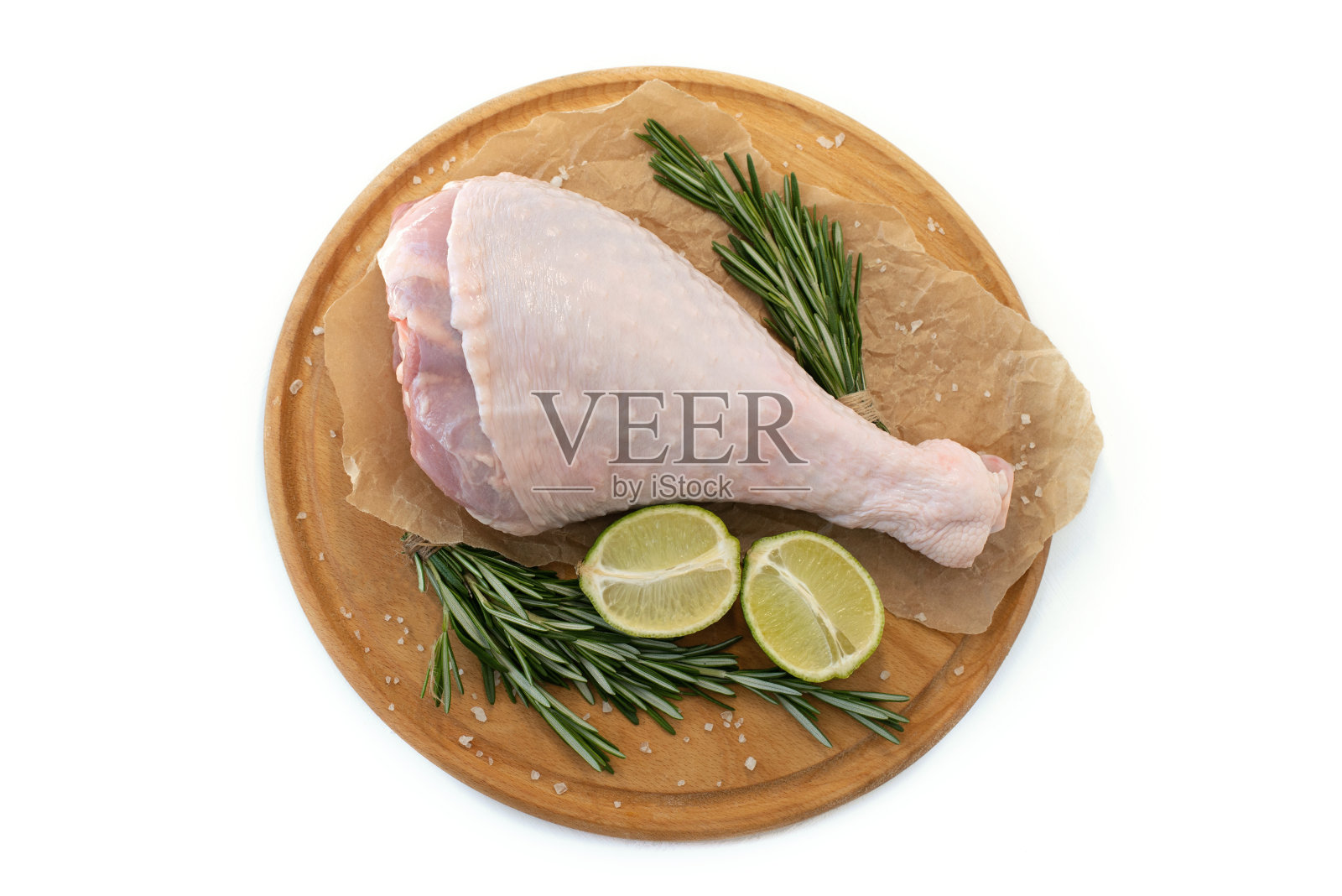 将火鸡腿与酸橙和欧芹分开放在白色的背景上照片摄影图片