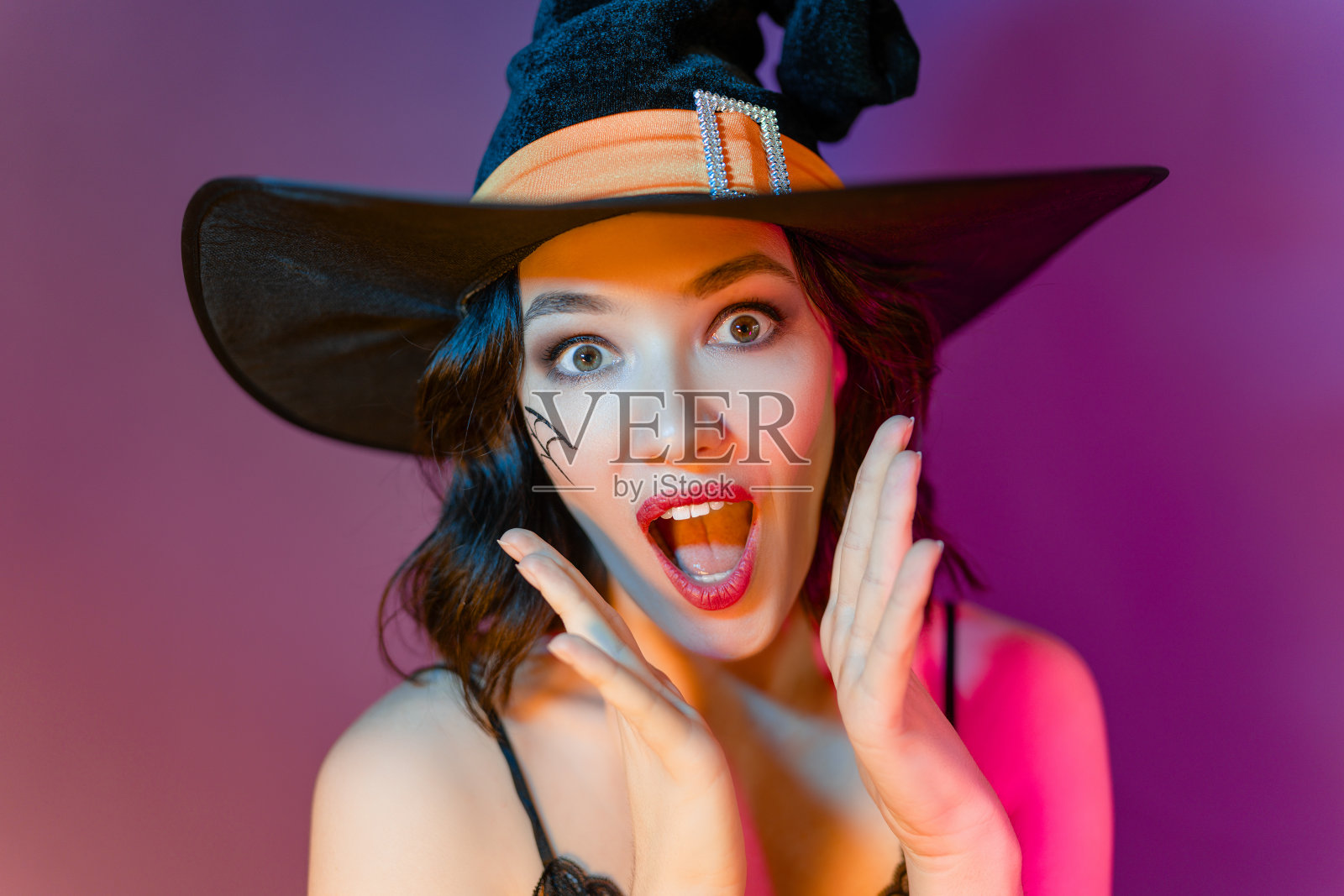 穿着黑女巫服装的年轻女人照片摄影图片