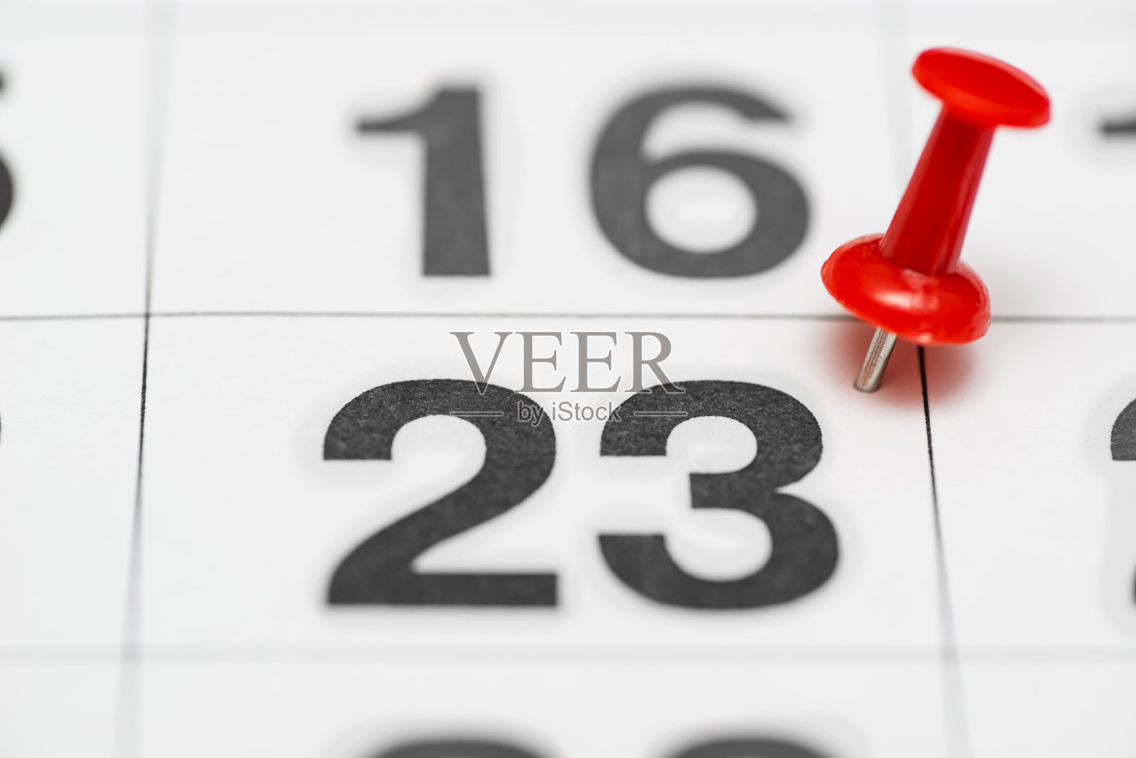 别上日期23。这个月的第二十三天用一个红色的图钉标出。销在日历照片摄影图片