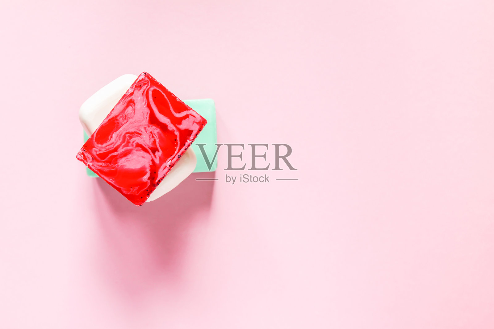 不同颜色的肥皂在软粉色的背景照片摄影图片