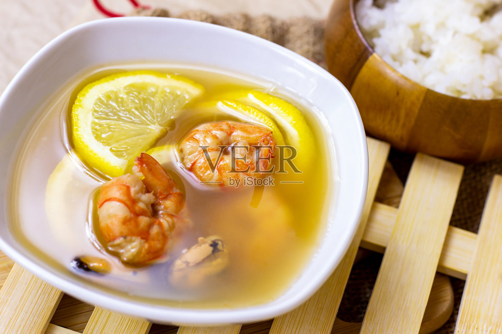 白色的碗，传统的淡辣泰国菜冬山药汤，虾，海鲜和柠檬在木板的背景照片摄影图片