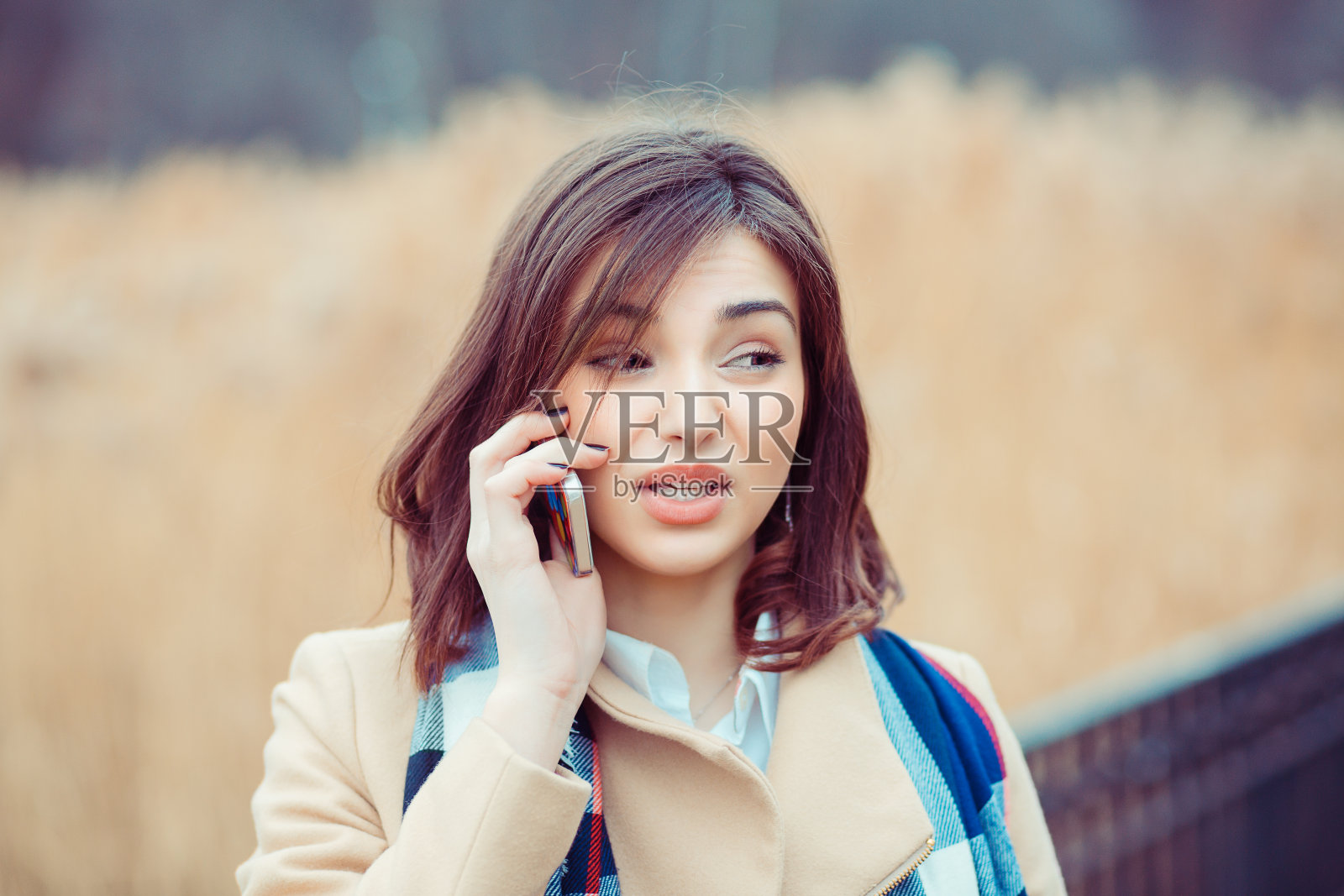 持怀疑态度的女人在公园里打电话，决定回答什么问题照片摄影图片