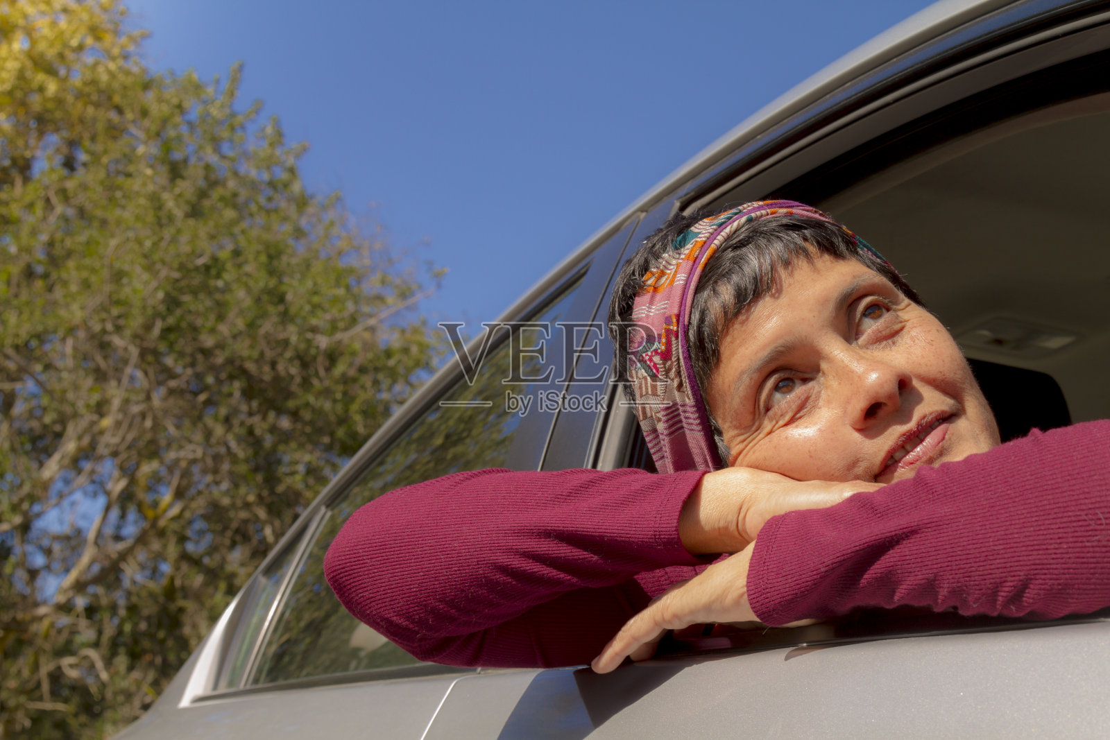 享受阳光明媚的一天和汽车的中年妇女照片摄影图片