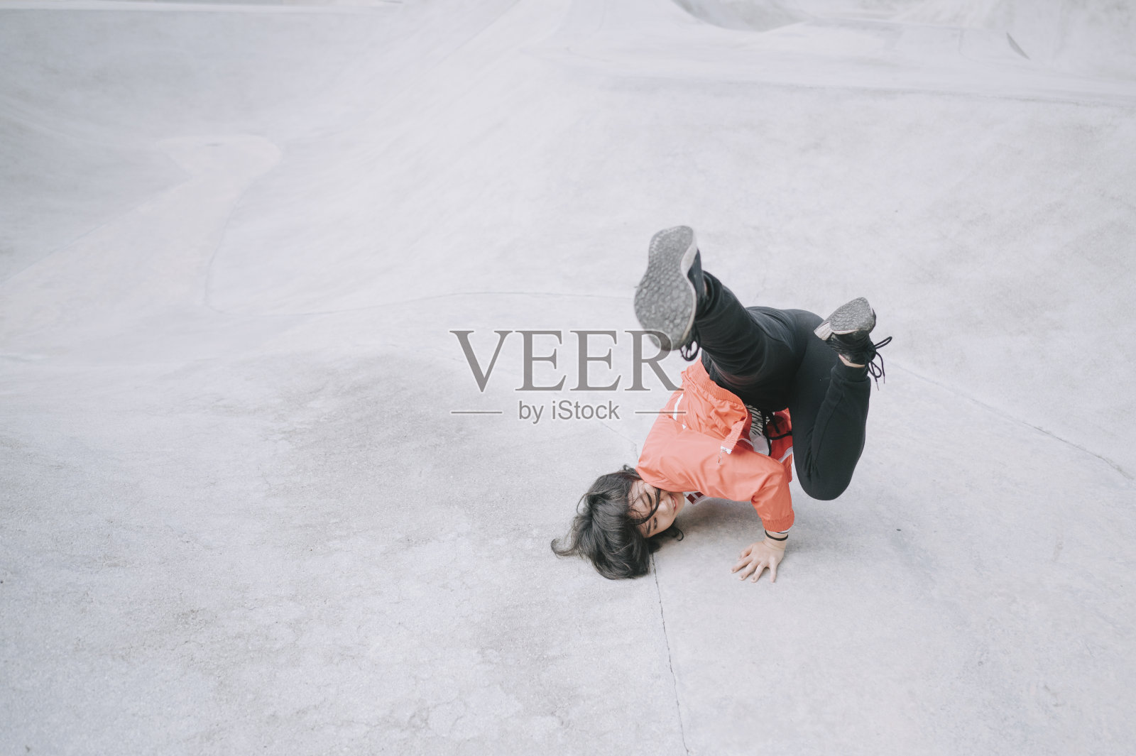 早上，一个小女孩在公园里练习霹雳舞照片摄影图片