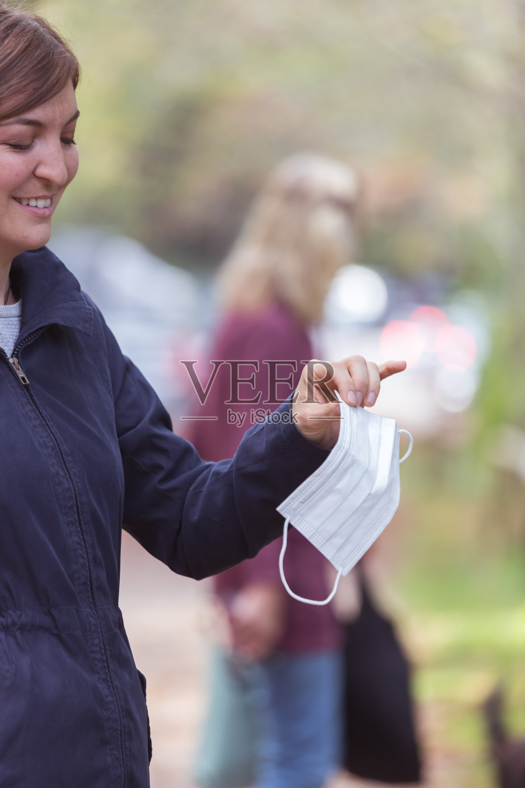 烟道和电晕安全概念。妇女拿着一次性口罩，在户外照片摄影图片
