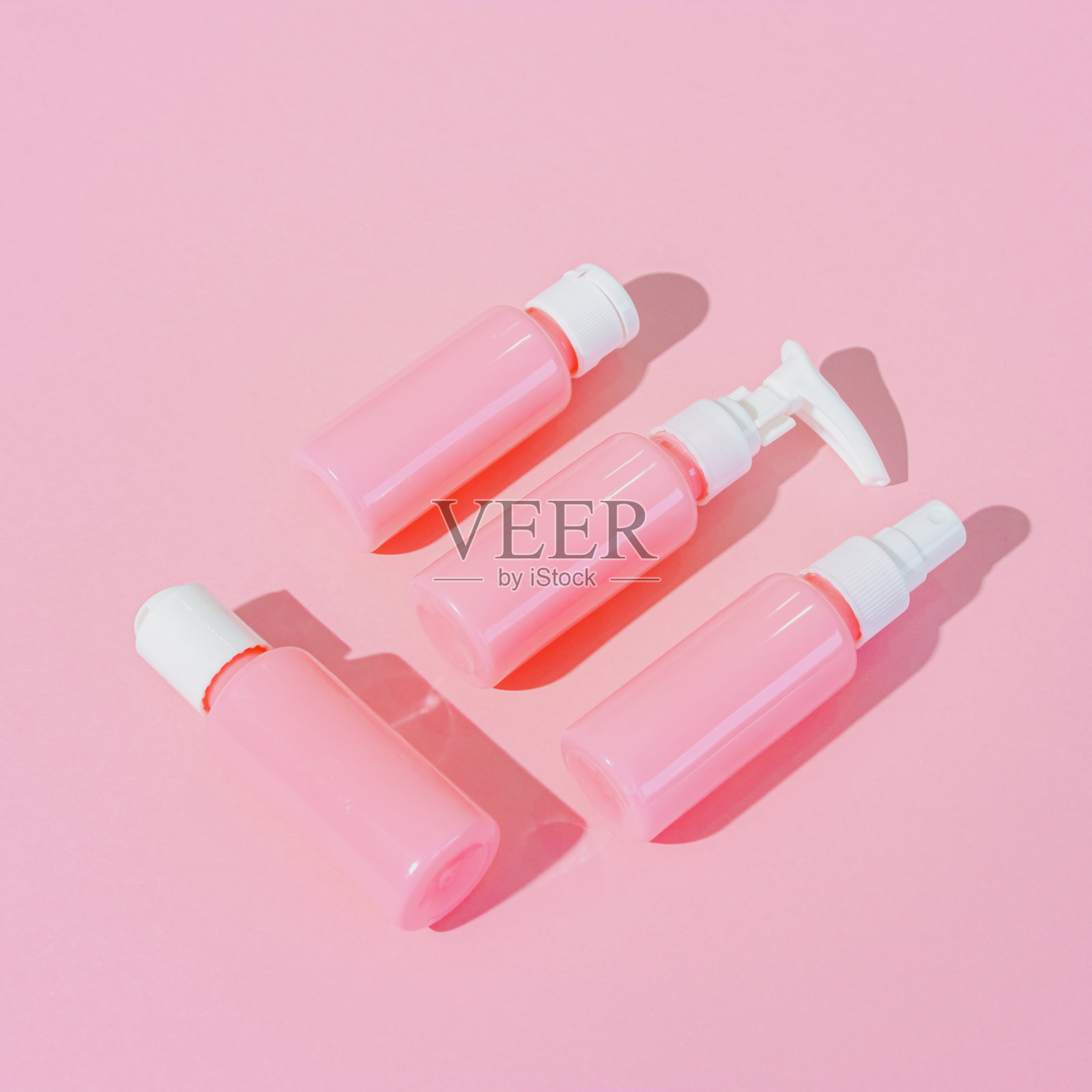 化妆品霜空白瓶。粉红色背景上的有机生物产品。简约的美容和水疗概念。静物单色照片摄影图片