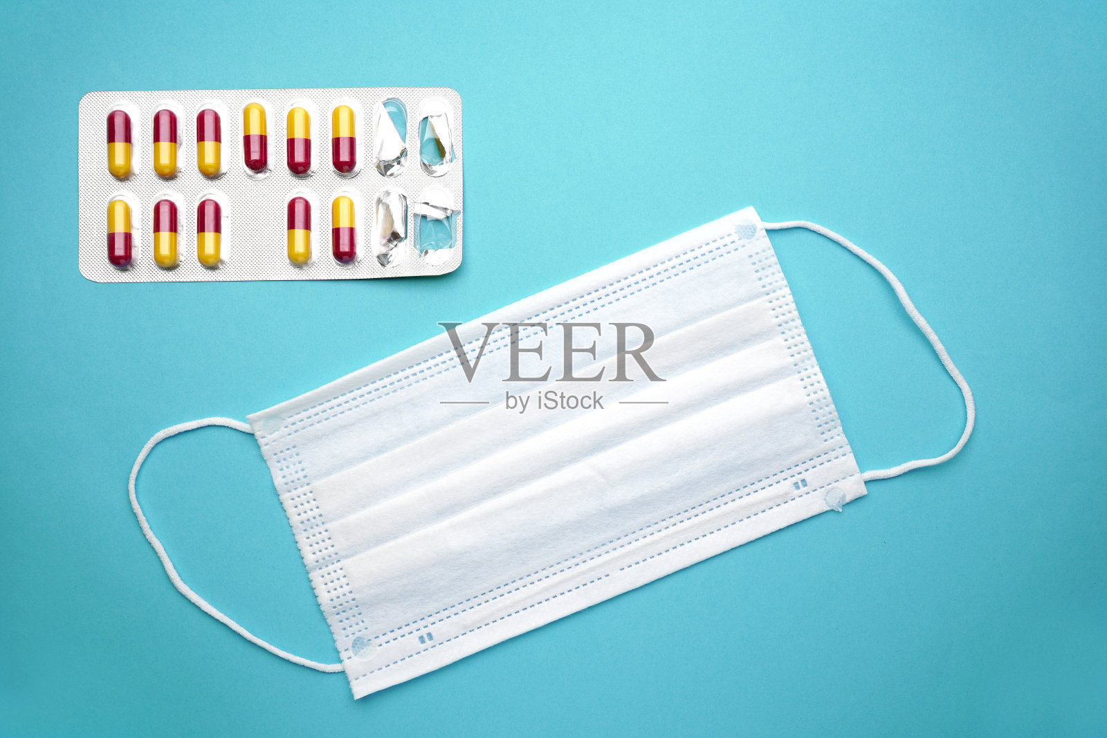 医用胶囊口罩隔离在蓝色背景上照片摄影图片