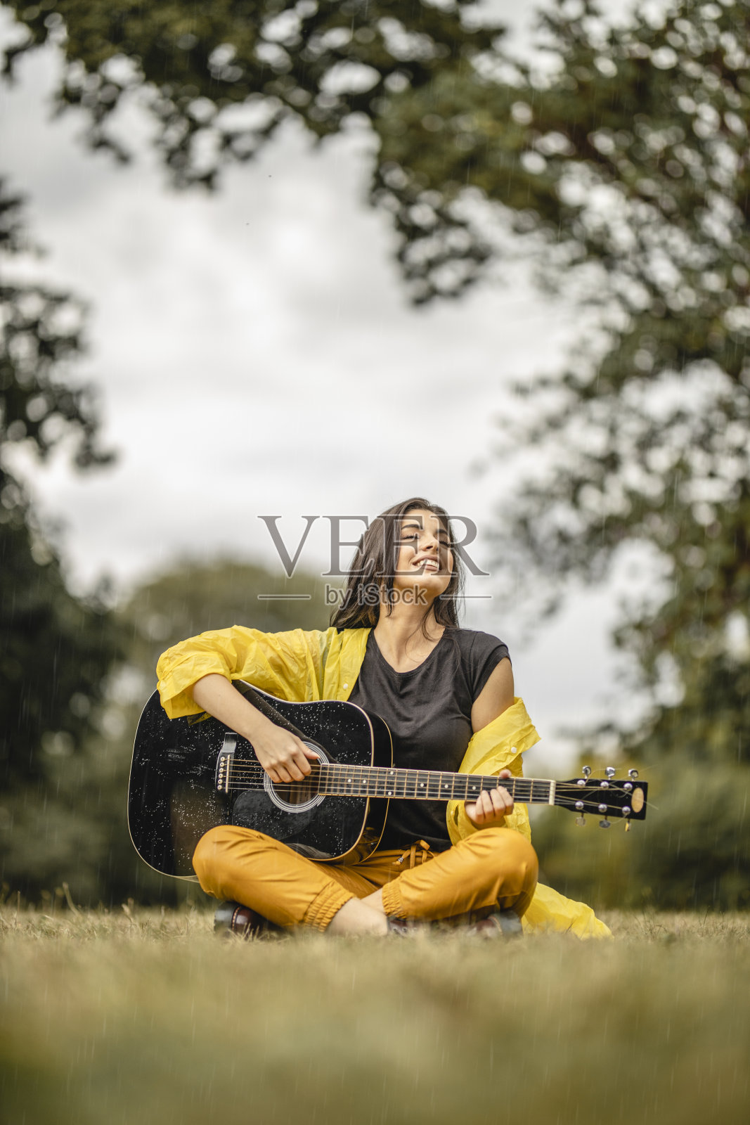 美丽的年轻女子在户外弹奏原声吉他照片摄影图片