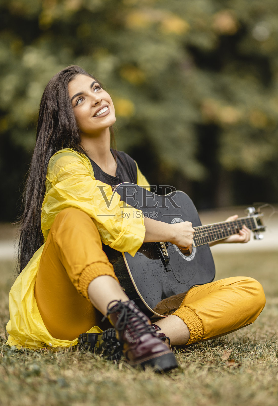 美丽的年轻女子在户外弹奏原声吉他照片摄影图片