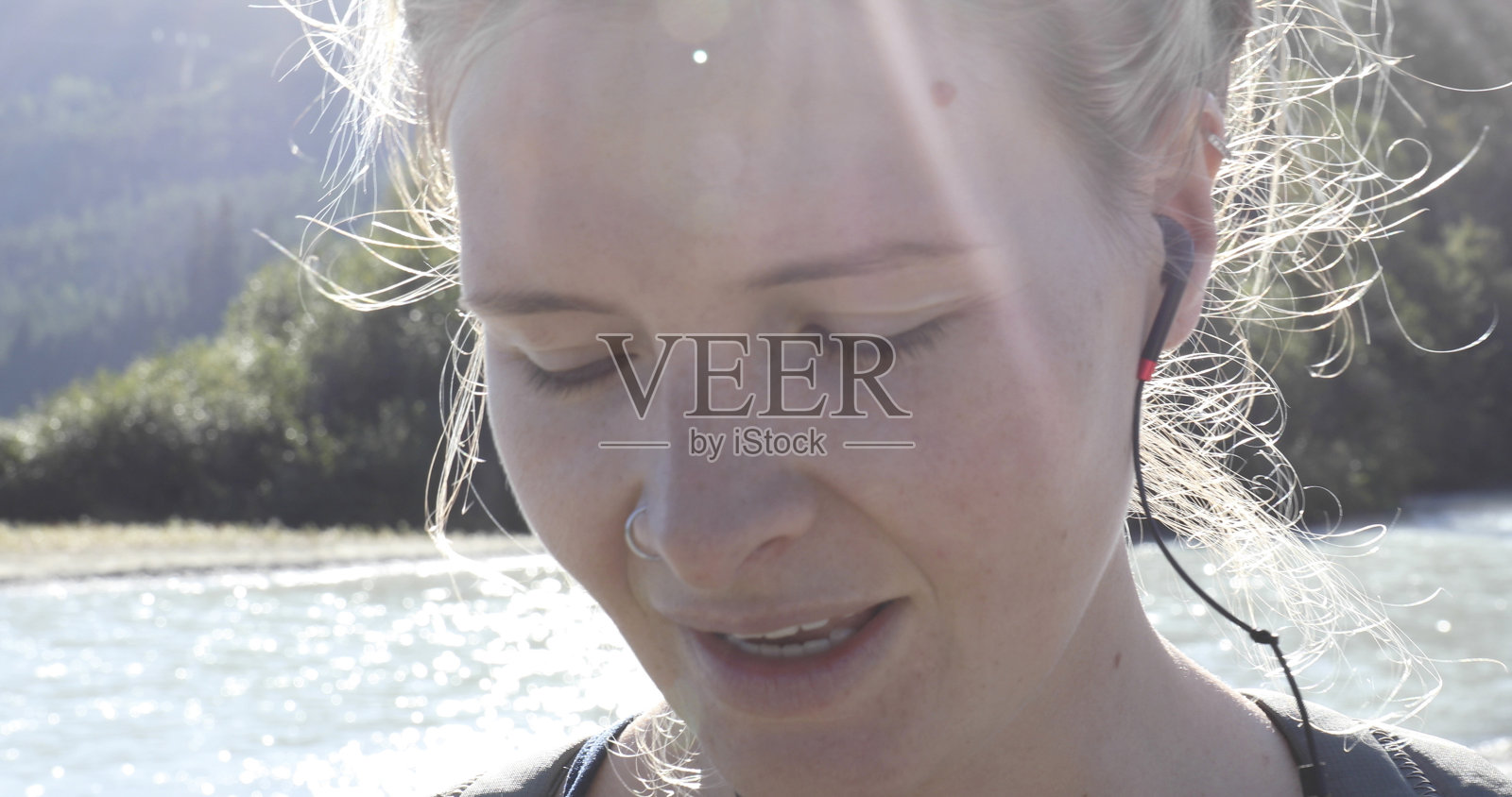 近距离的年轻女子享受音乐的高山湖照片摄影图片