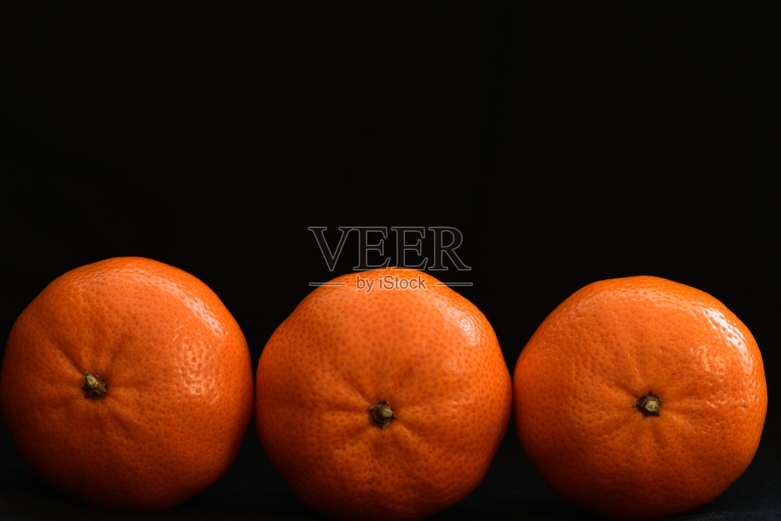 桔黄色水果在黑色的背景。照片摄影图片