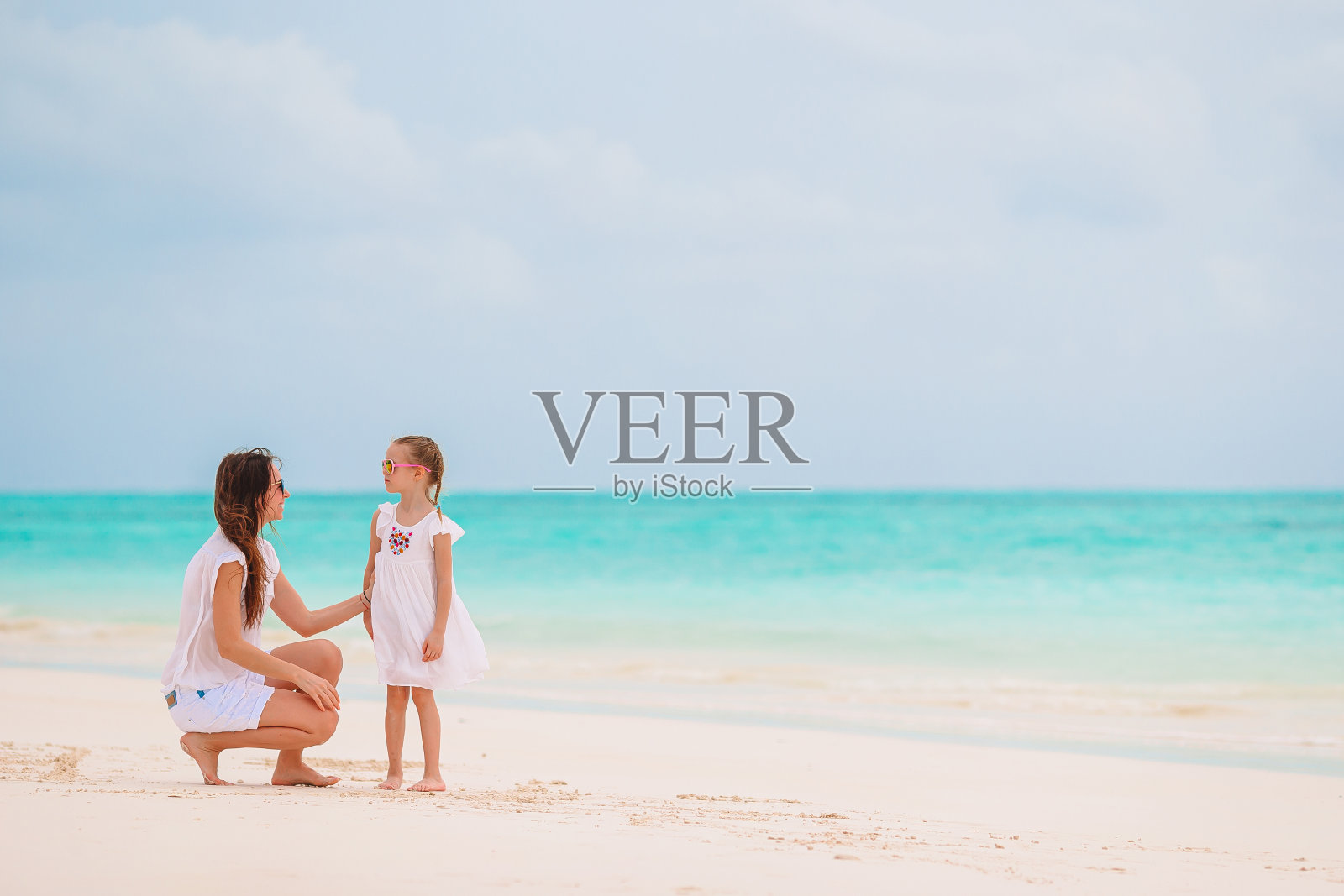 美丽的母亲和女儿在加勒比海滩享受暑假。照片摄影图片