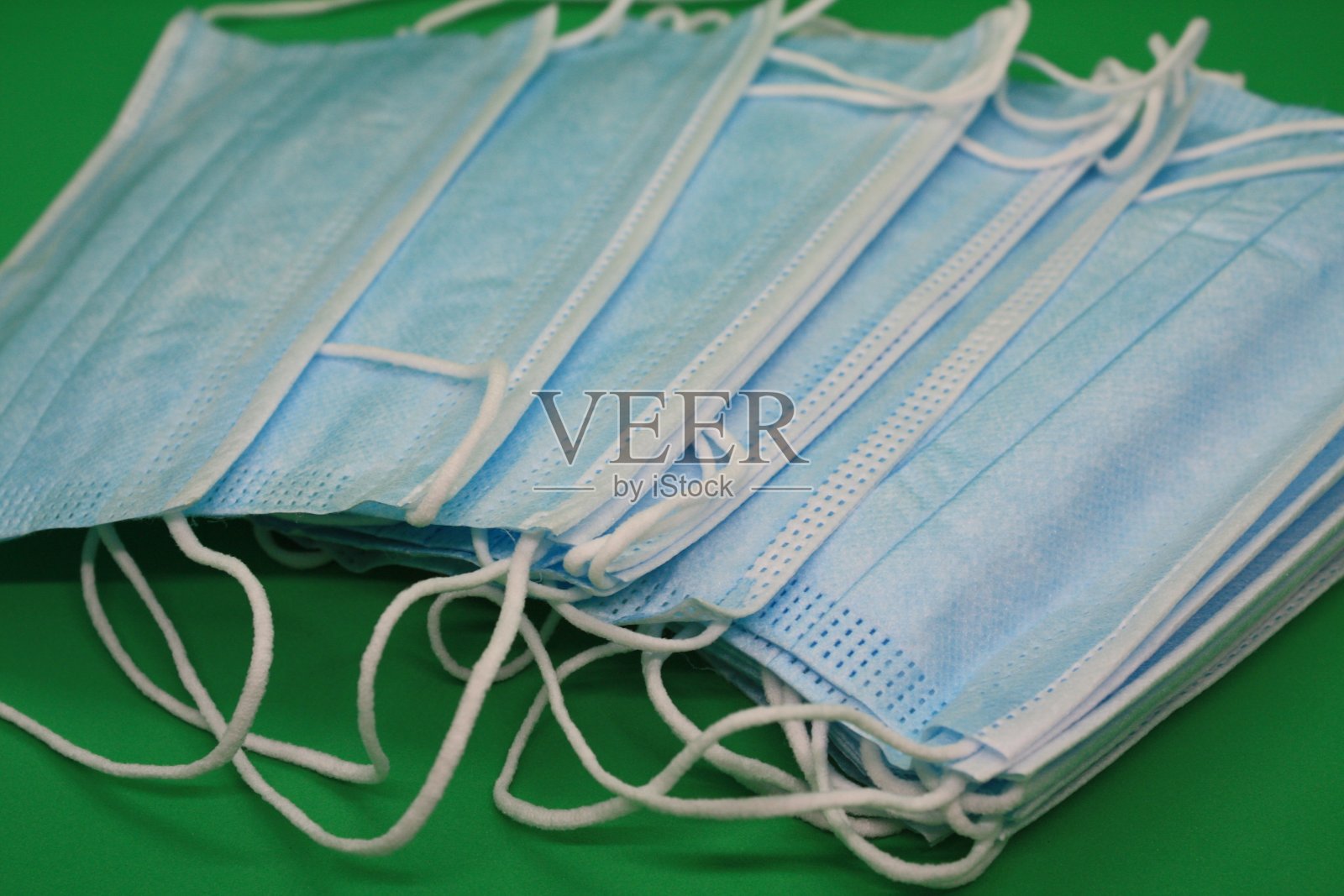 绿色背景下的医用口罩照片摄影图片