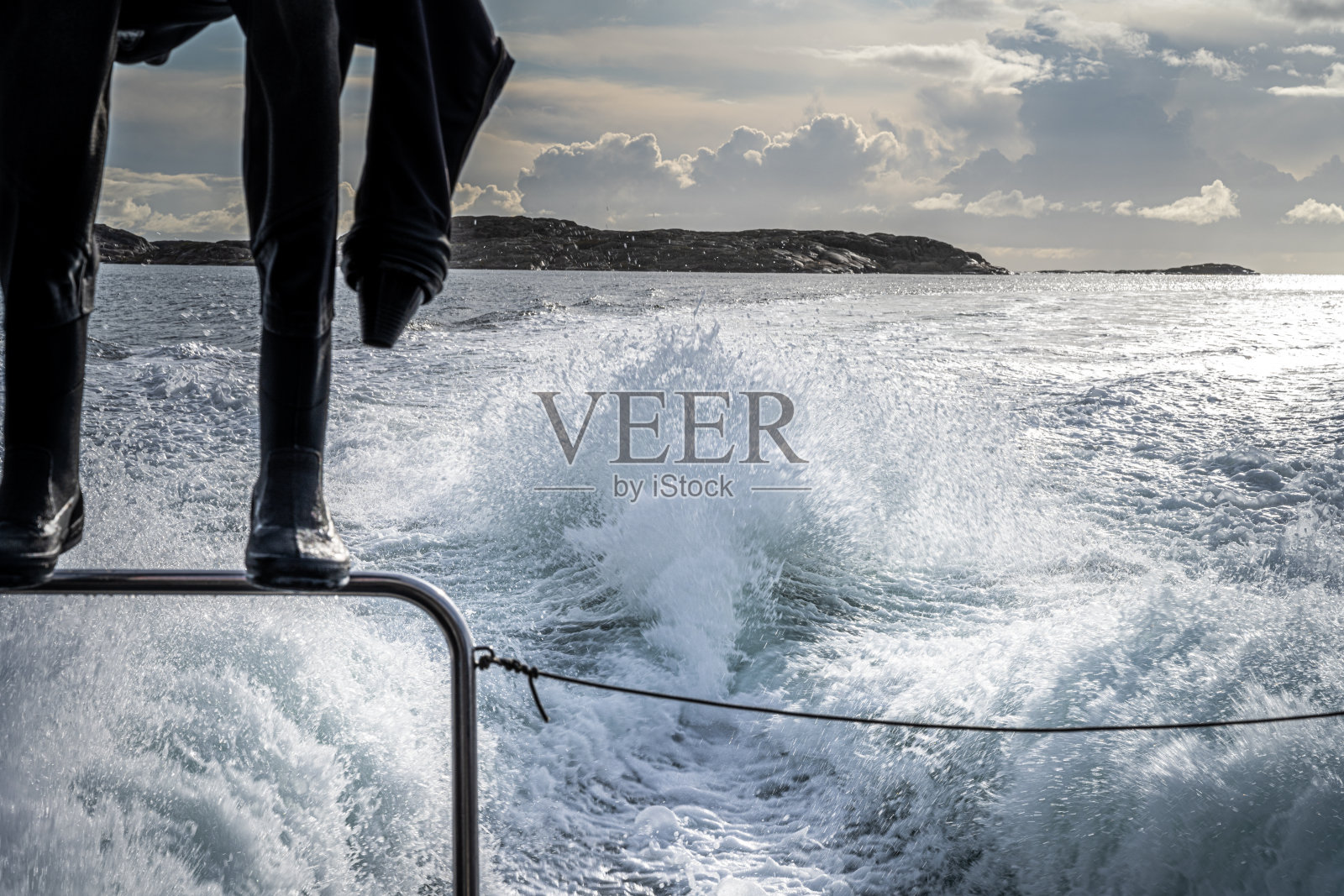 从一艘快速潜水船的船尾看到的美丽景色。一件悬挂着水肺潜水服，背景是蓝色的海洋和天空照片摄影图片