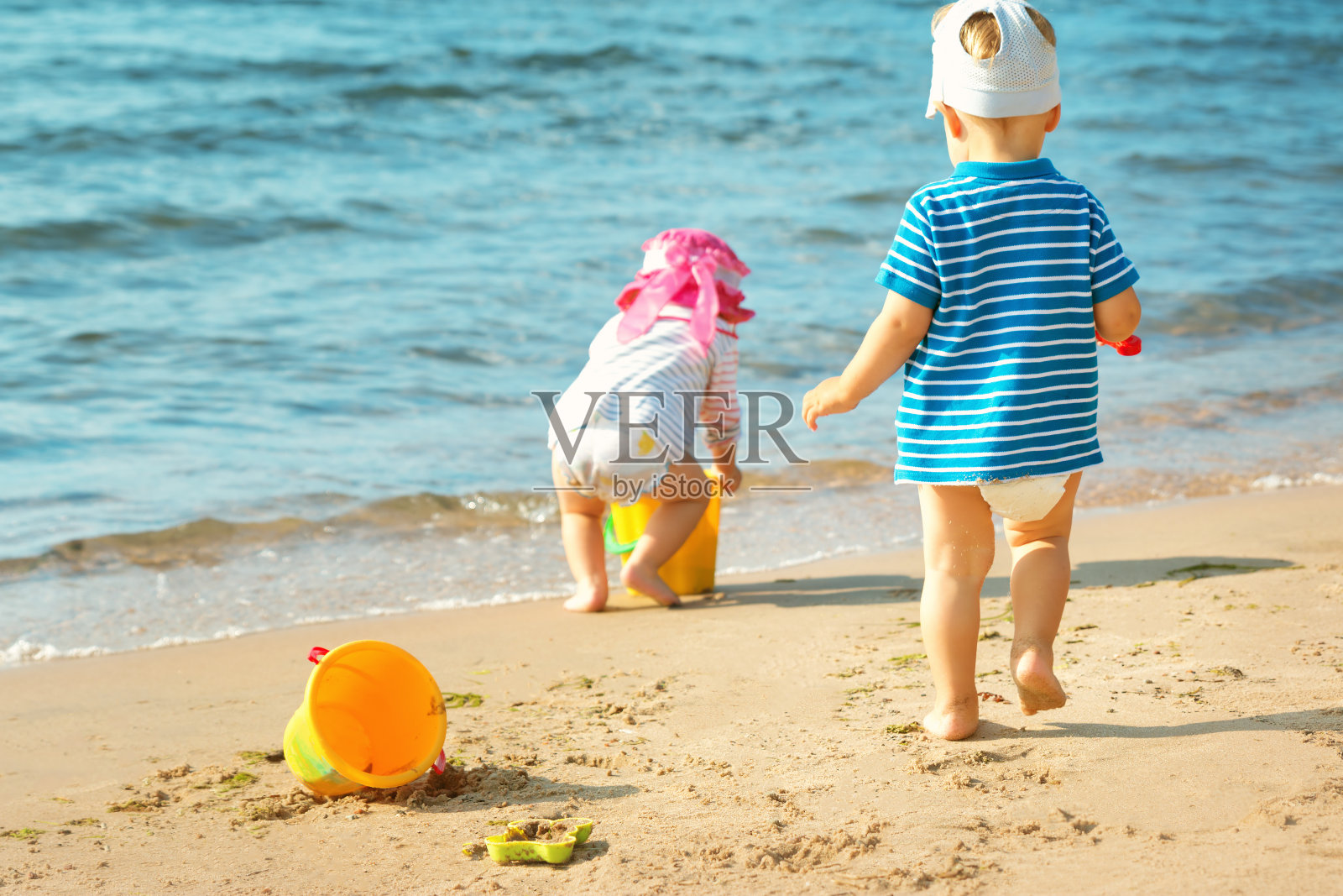 小女孩和小男孩在海滩上玩耍照片摄影图片