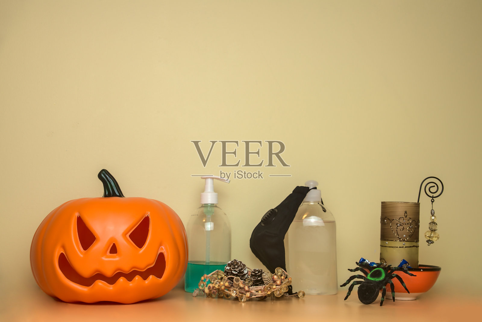 2020年万圣节的背景是美丽舒适的，配有吓人的南瓜和蜘蛛、糖果和蜡烛、洗手液、酒精凝胶和预防新冠肺炎的口罩。本空间照片摄影图片