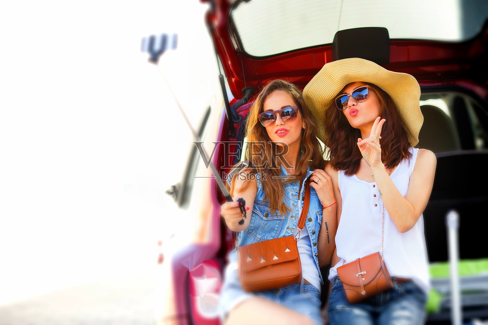 两个女性朋友坐在敞开的汽车后备箱里聊天照片摄影图片