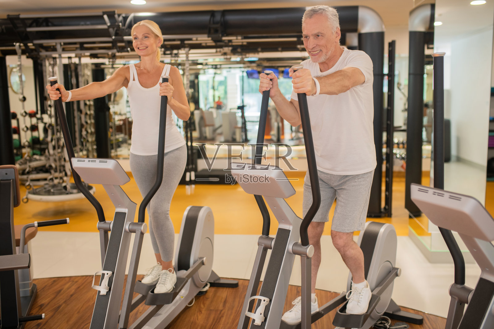 成熟的情侣一起在健身房锻炼，看起来很坚定照片摄影图片