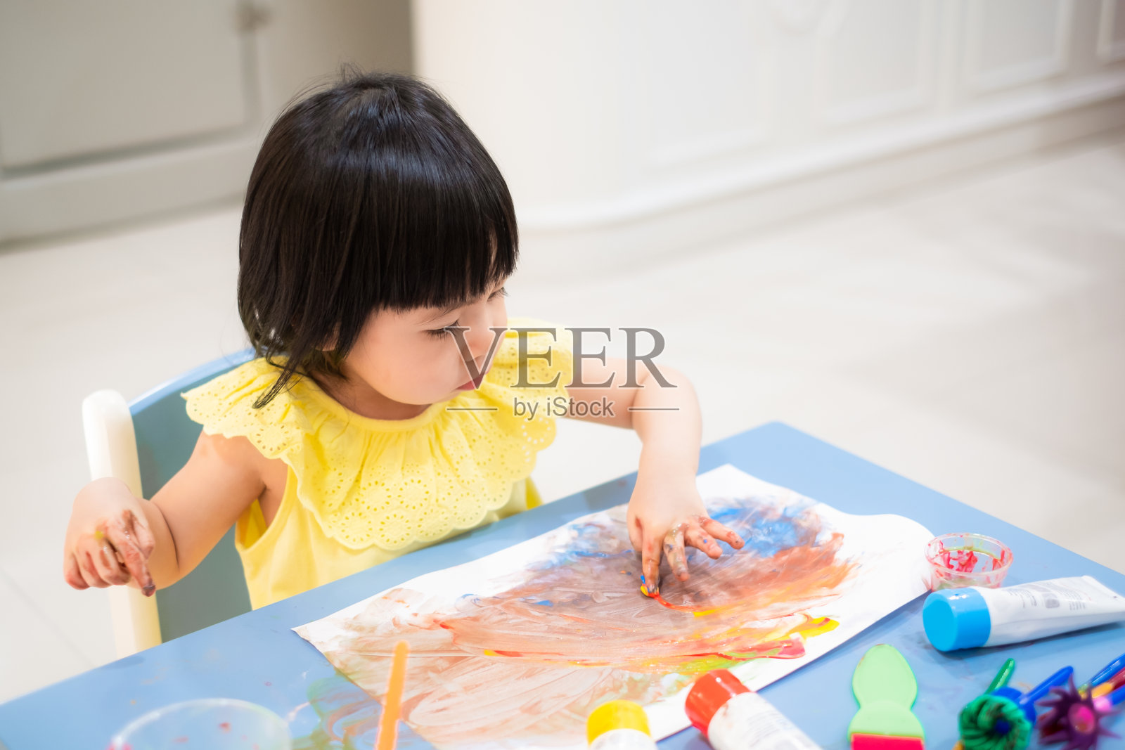 亚洲幼童女孩用手画水彩。照片摄影图片