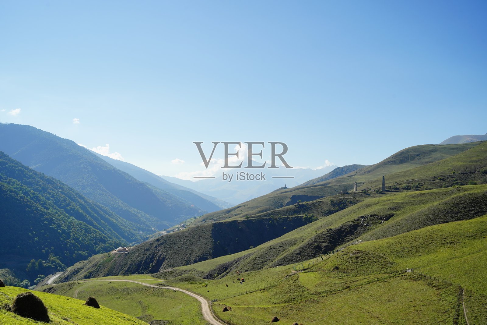 夏季山水风光秀丽。在晴朗的日子里，蓝天下的高原山谷和绿色草地的壮丽景色照片摄影图片