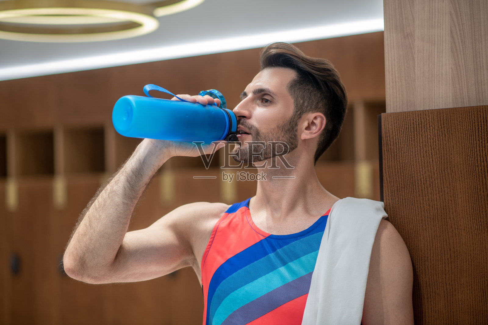 穿着鲜艳t恤的年轻人在运动后感到口渴照片摄影图片