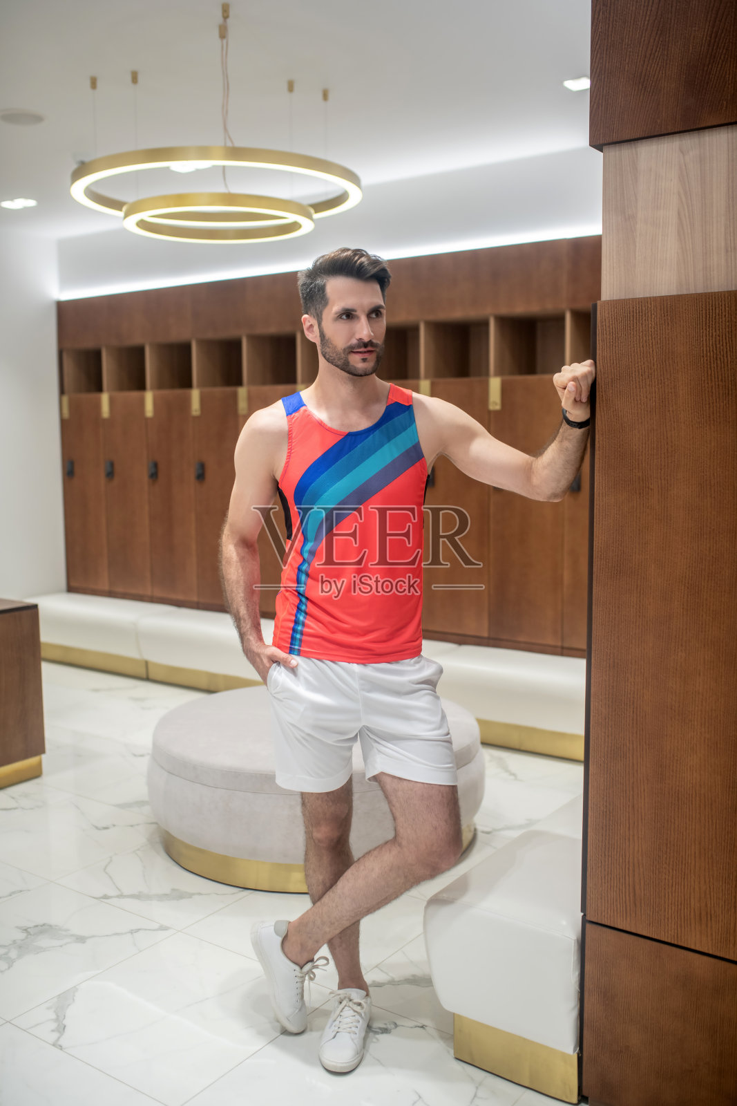 穿着鲜艳t恤的年轻人站在更衣室里照片摄影图片