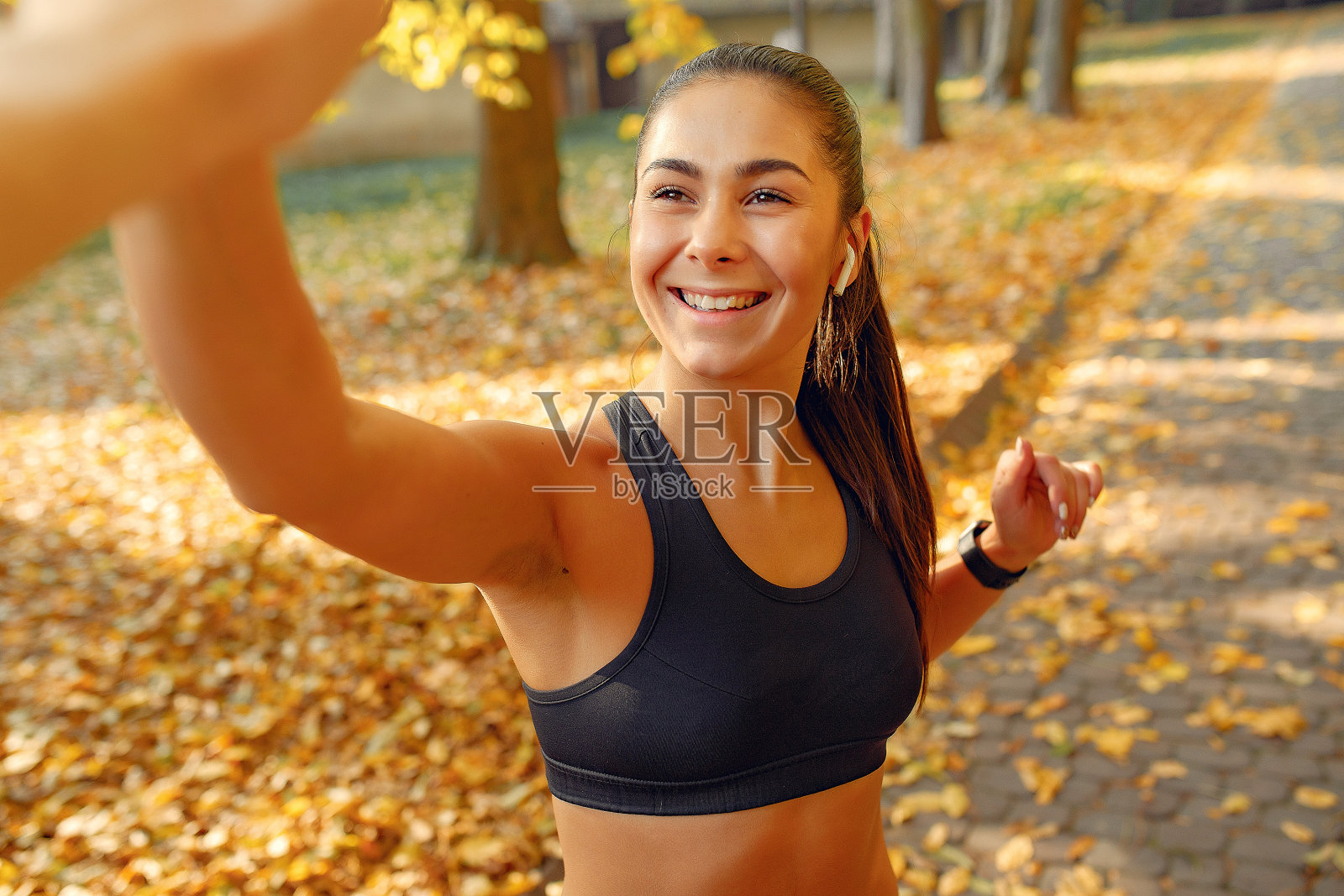 运动女孩在一个秋天的公园里穿着黑色上衣训练照片摄影图片