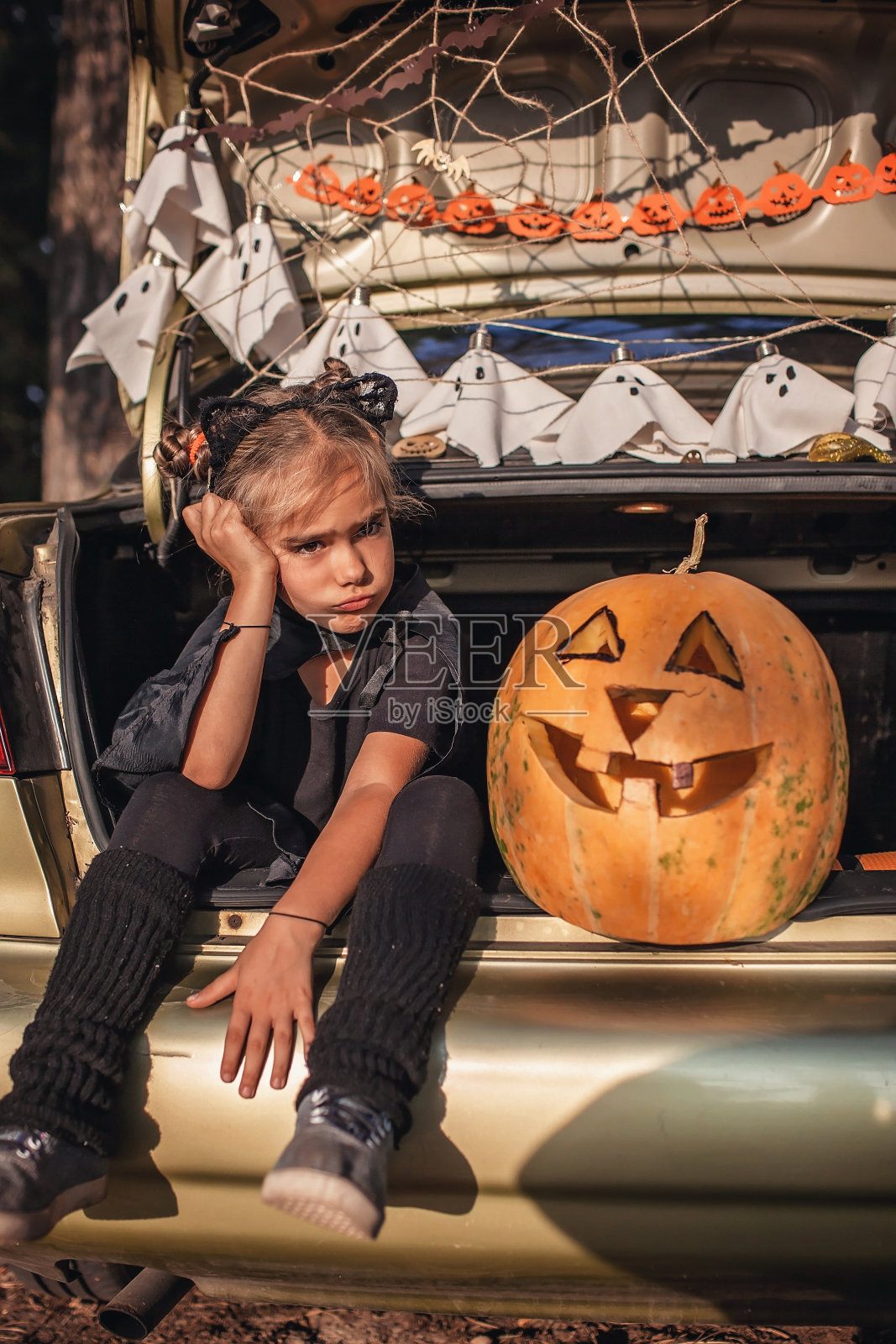 平安遥远庆祝万圣节。孩子们在汽车后备箱里为派对准备装饰照片摄影图片