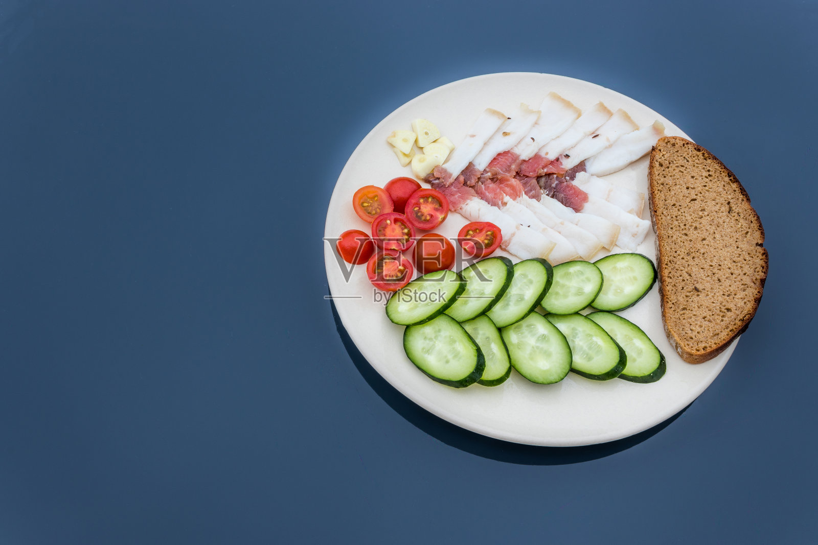 切片的咸猪油配黄瓜、番茄和面包。俄罗斯传统小吃。照片摄影图片