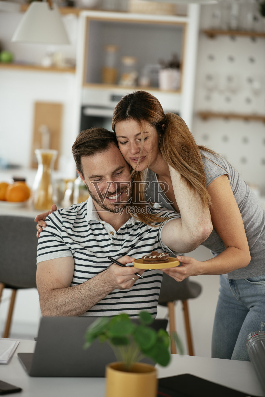 年轻女子用饼干给丈夫一个惊喜。照片摄影图片