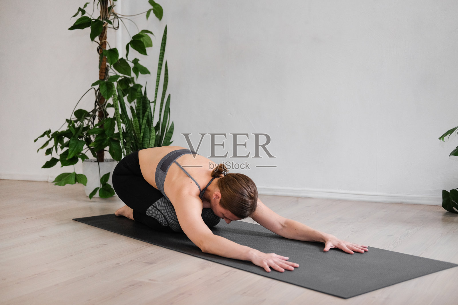 一个妇女在隔离期间在家做哈他瑜伽照片摄影图片