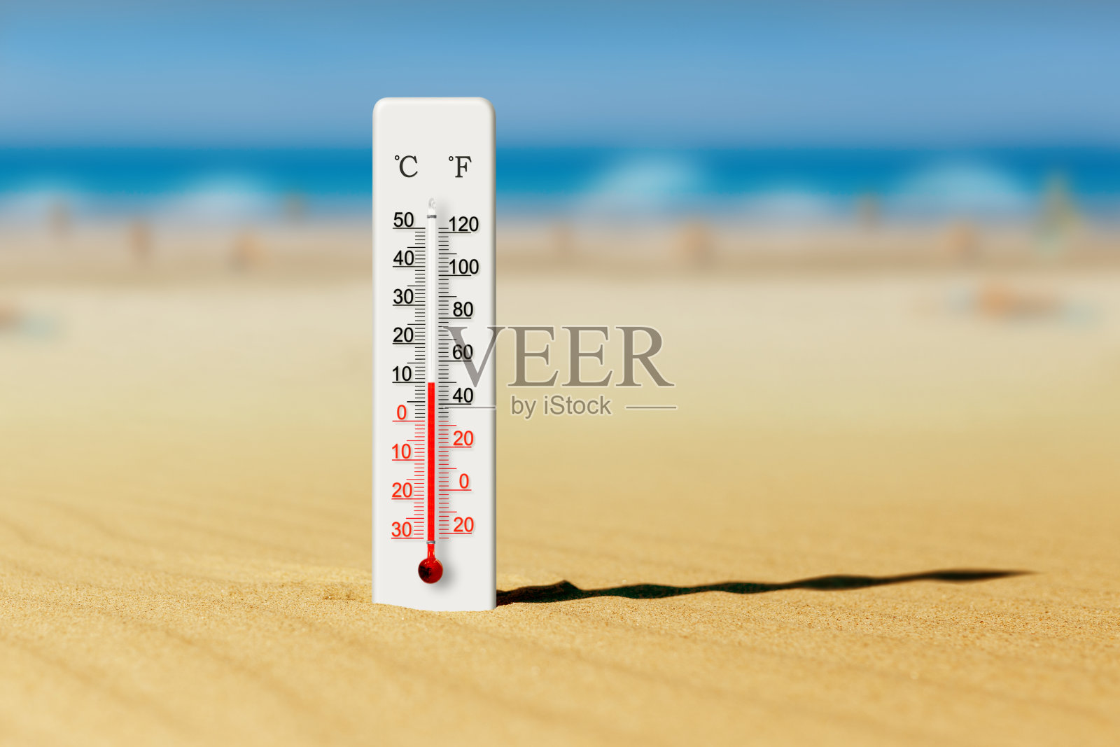 海边在炎热的夏天。沙子里的温度计显示摄氏十度照片摄影图片