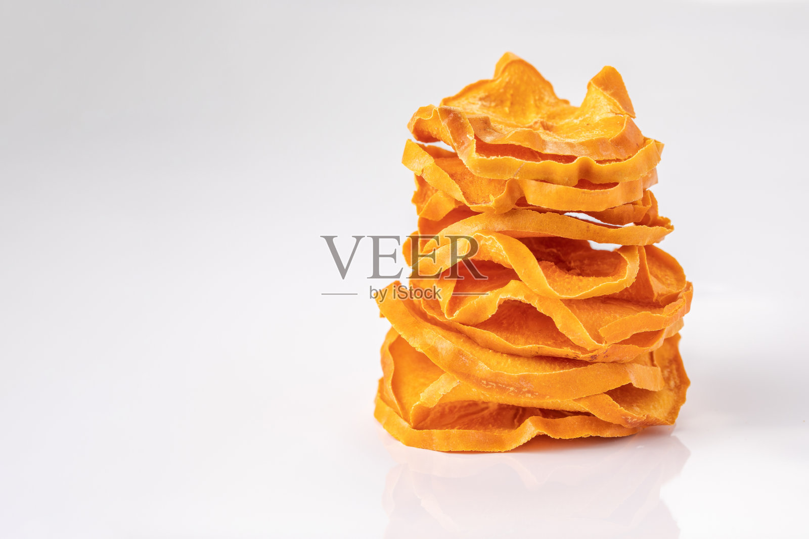 白底上的干柿子片。干果。生态。宏。照片摄影图片