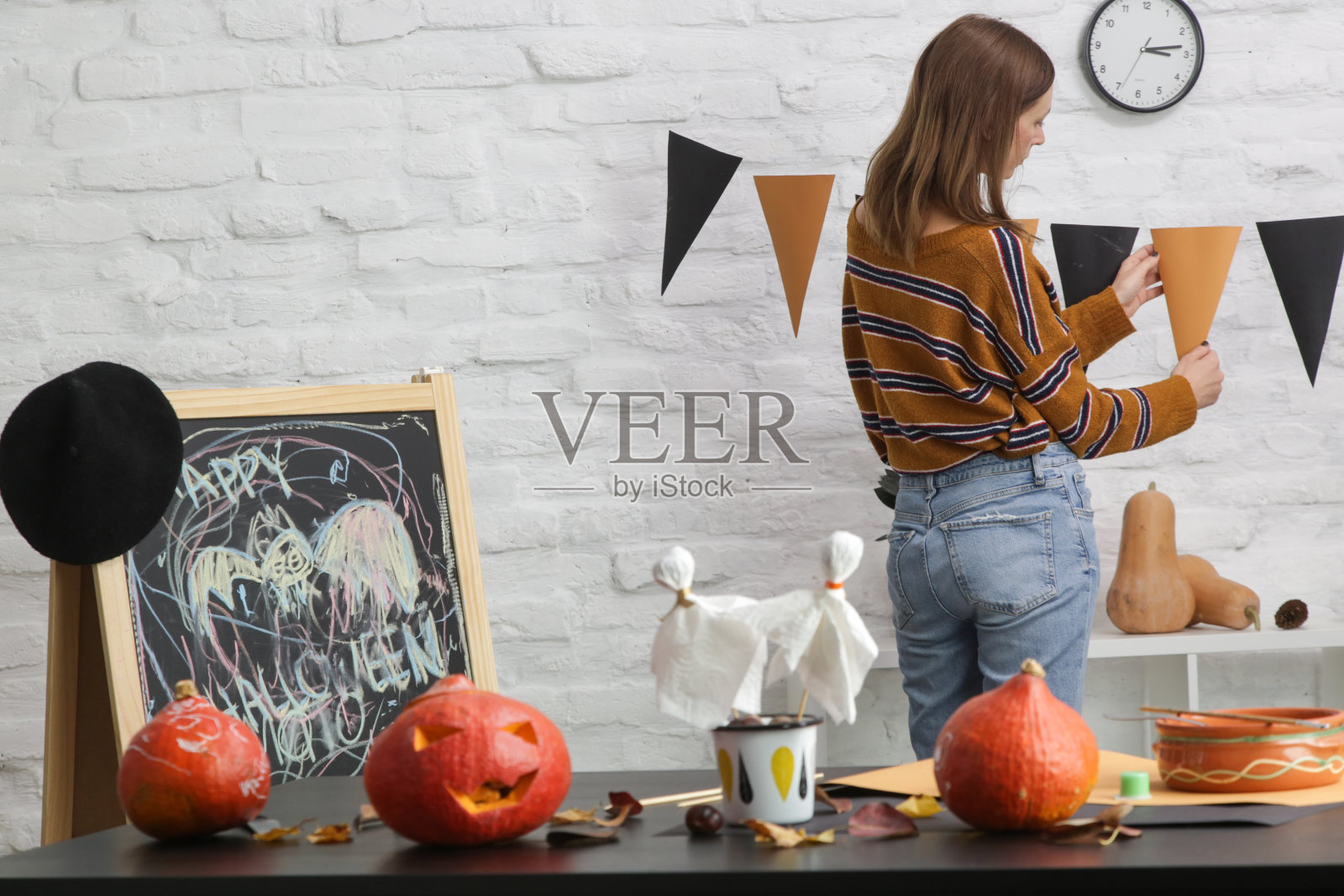 年轻女子在家制作万圣节装饰。秋季DIY工艺。照片摄影图片