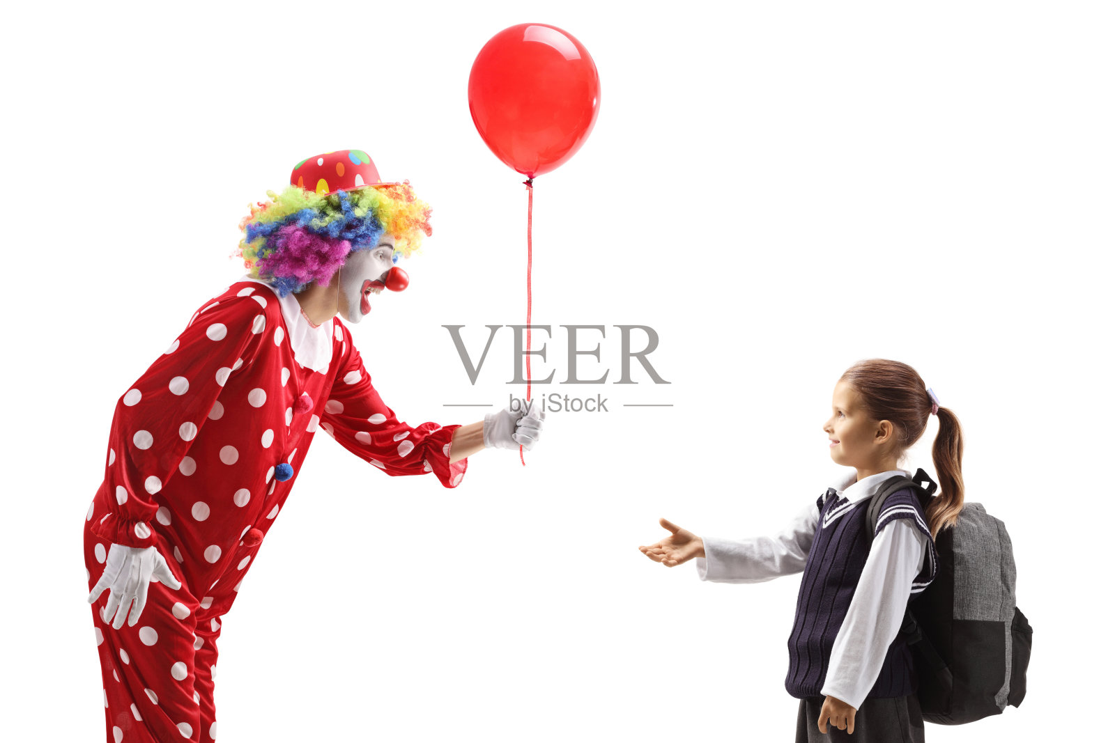 快乐的小丑给一个女学生一个红色的气球照片摄影图片