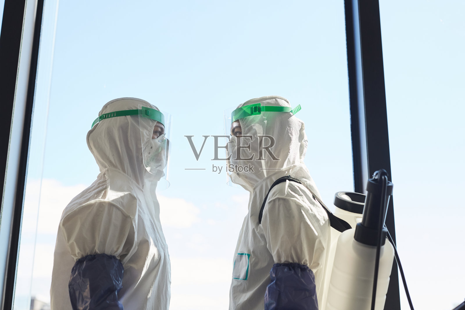 消毒人员对着窗户照片摄影图片