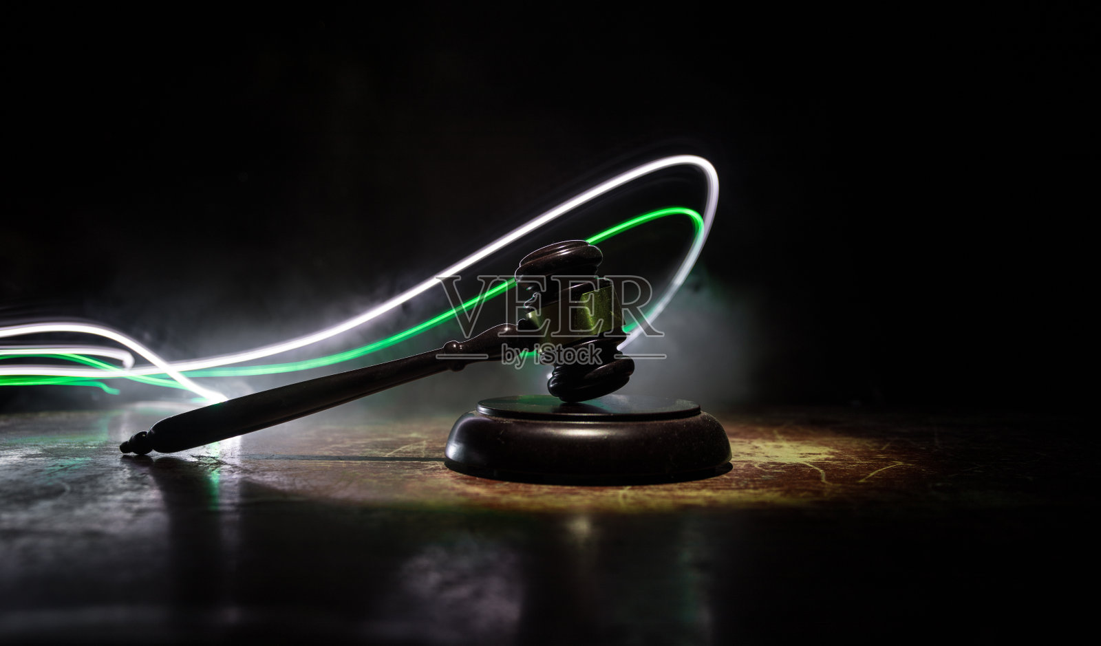 法律主题，法官木桌上的木槌。法律的小木槌在黑暗的雾蒙蒙的背景与光。有选择性的重点照片摄影图片