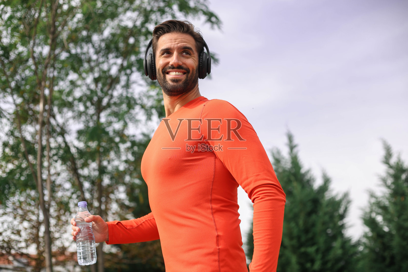 一个英俊的运动员在大自然中跑步、慢跑和锻炼时戴着耳机照片摄影图片